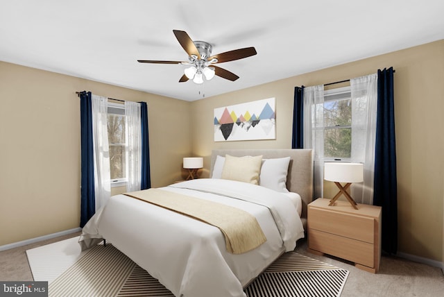 bedroom with light carpet, multiple windows, and baseboards