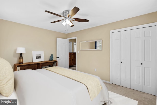 bedroom featuring light carpet, a closet, a ceiling fan, and baseboards