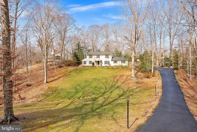 view of front of home with aphalt driveway and a front yard