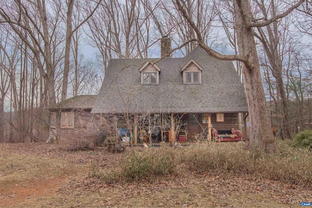 view of front of property with roof with shingles and a chimney