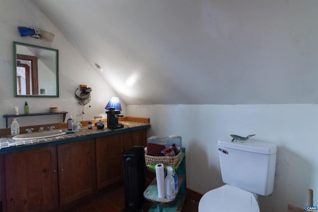 bathroom featuring lofted ceiling, toilet, and vanity