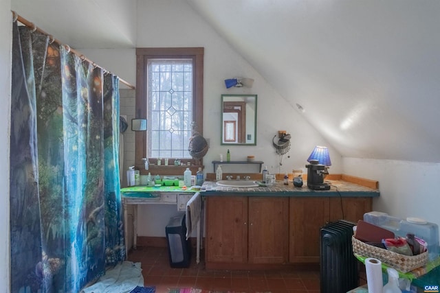 interior space with lofted ceiling, radiator, a sink, and tile patterned floors