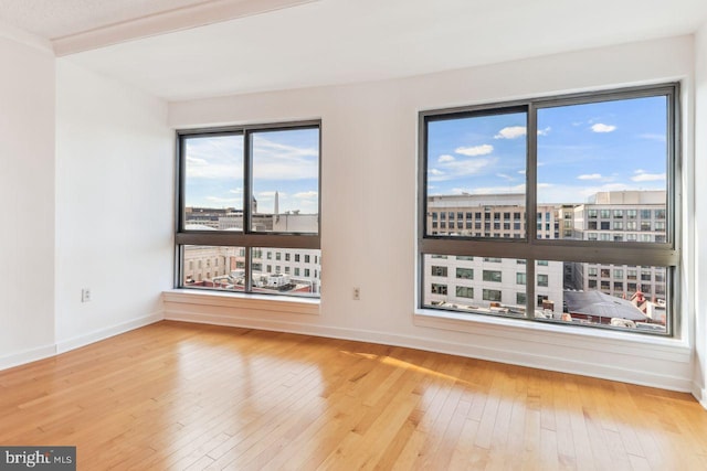 empty room featuring wood-type flooring and baseboards