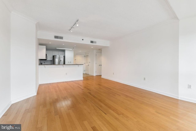 unfurnished living room with crown molding, baseboards, visible vents, and light wood-style floors