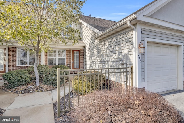 view of exterior entry with a garage and brick siding