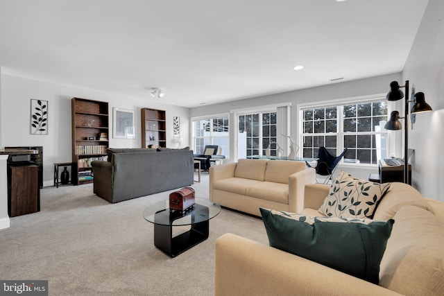 living room featuring light carpet, baseboards, and recessed lighting