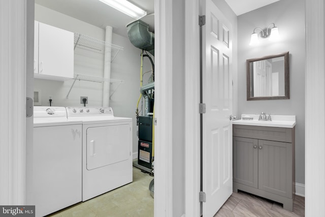 laundry area with a sink, laundry area, baseboards, and washer and dryer