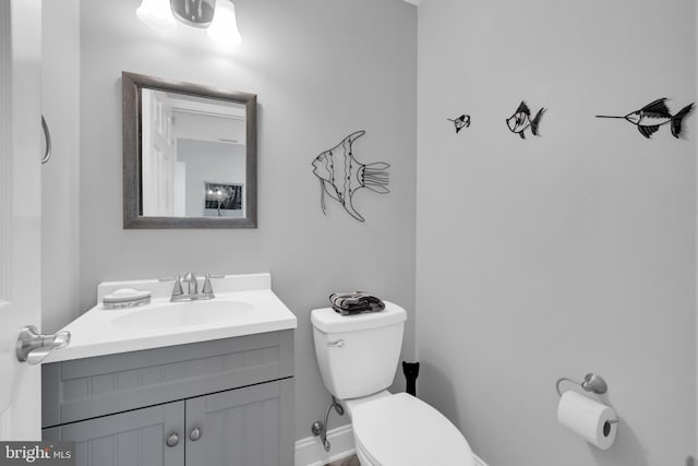 bathroom featuring vanity, toilet, and baseboards