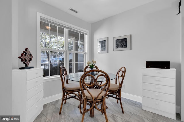 dining space featuring marble finish floor, baseboards, and visible vents