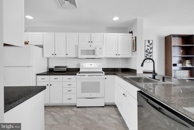 kitchen featuring white appliances, a sink, visible vents, white cabinetry, and tasteful backsplash