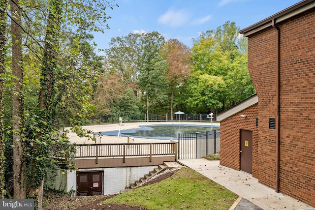 community pool featuring a lawn and fence