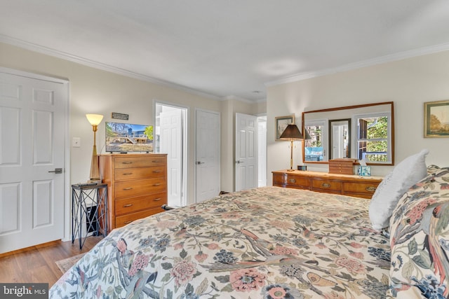 bedroom featuring crown molding and light wood finished floors