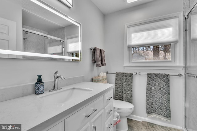 bathroom featuring toilet, a shower stall, and vanity