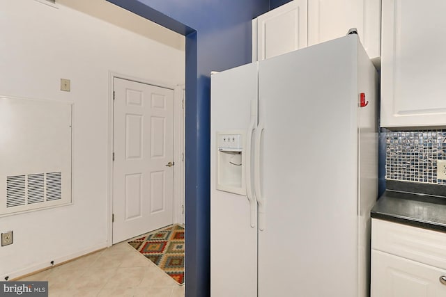 kitchen with white refrigerator with ice dispenser, white cabinetry, tile patterned floors, tasteful backsplash, and dark countertops