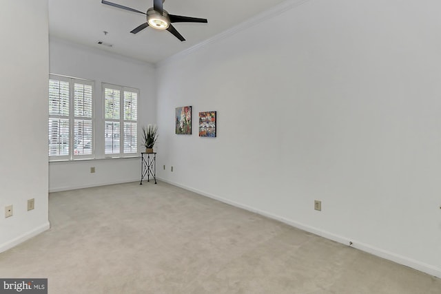 empty room featuring visible vents, ornamental molding, a ceiling fan, carpet flooring, and baseboards