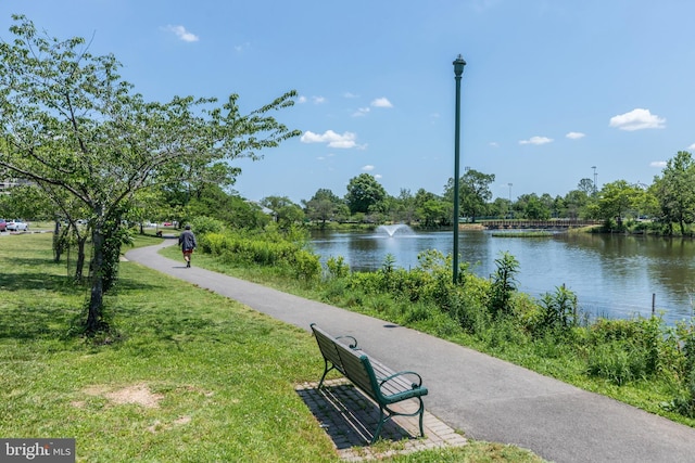 view of home's community with a lawn and a water view