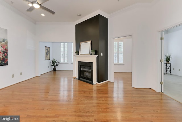 living area with a fireplace with flush hearth, ceiling fan, crown molding, light wood-style floors, and recessed lighting