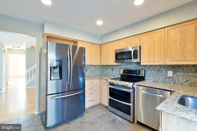 kitchen with light stone counters, light brown cabinets, recessed lighting, appliances with stainless steel finishes, and tasteful backsplash