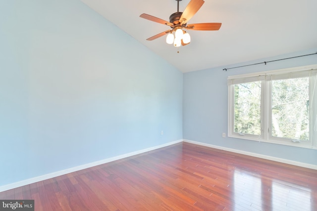 unfurnished room featuring vaulted ceiling, ceiling fan, wood finished floors, and baseboards