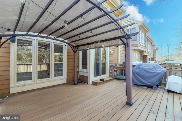 wooden deck with area for grilling and a pergola