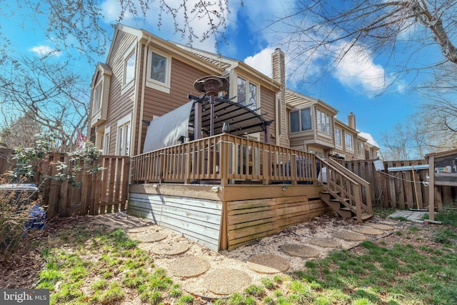 exterior space with a chimney, fence, and a wooden deck