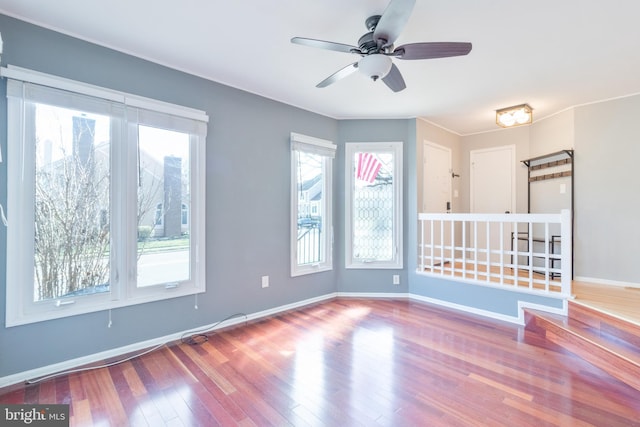 spare room with ceiling fan, wood finished floors, and baseboards