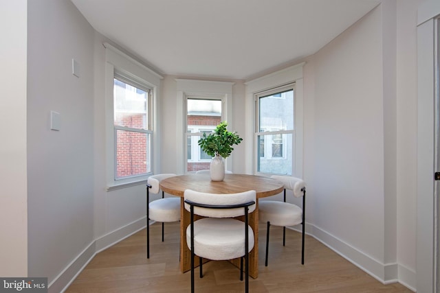 dining space featuring light wood-style floors and baseboards