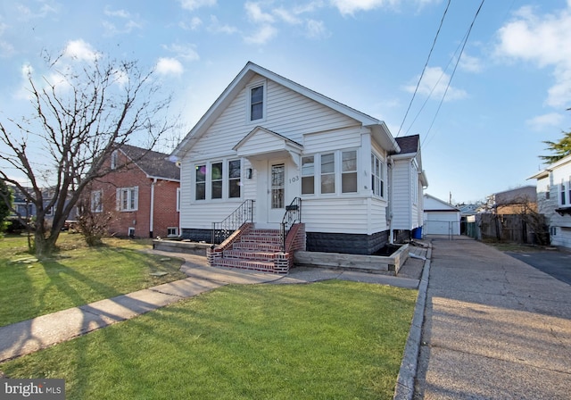 bungalow-style house featuring an outbuilding, a front lawn, and entry steps