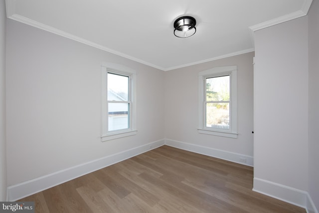 empty room featuring baseboards, ornamental molding, and wood finished floors