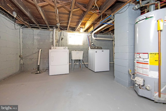 basement featuring water heater, washer and clothes dryer, and a sink