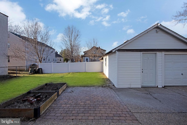 garage with a vegetable garden and fence