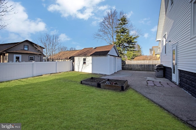 view of yard with an outbuilding, a patio, a fenced backyard, and a vegetable garden