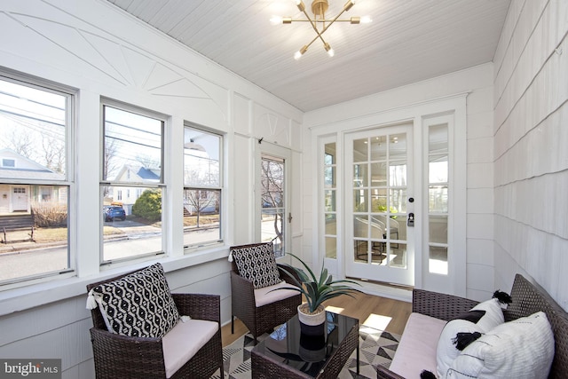 sunroom / solarium featuring a notable chandelier