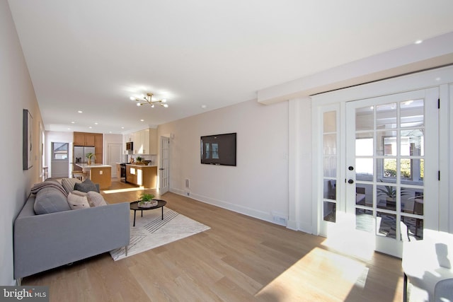 living room with light wood-type flooring, visible vents, baseboards, and recessed lighting