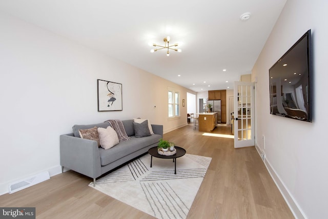 living room featuring recessed lighting, visible vents, light wood-style flooring, and baseboards