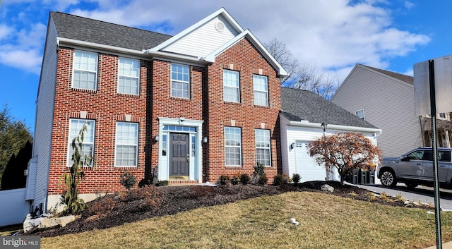 colonial-style house with a garage, driveway, brick siding, and a front yard