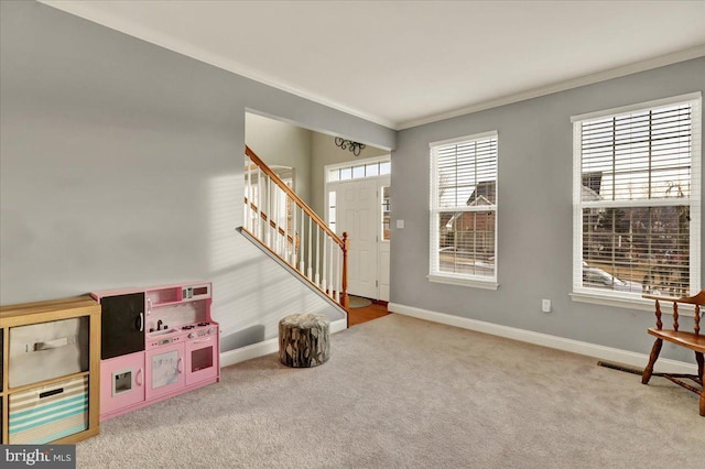 carpeted entrance foyer featuring stairway, baseboards, and crown molding