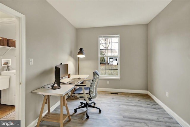 office space featuring light wood-style floors and baseboards