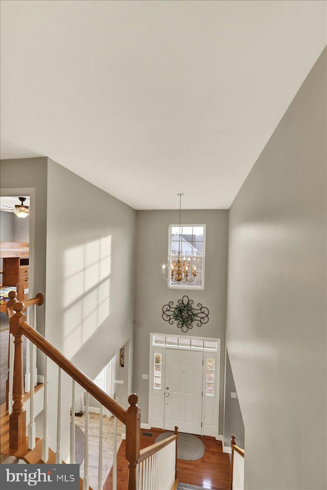 entryway with a chandelier, baseboards, a high ceiling, and wood finished floors