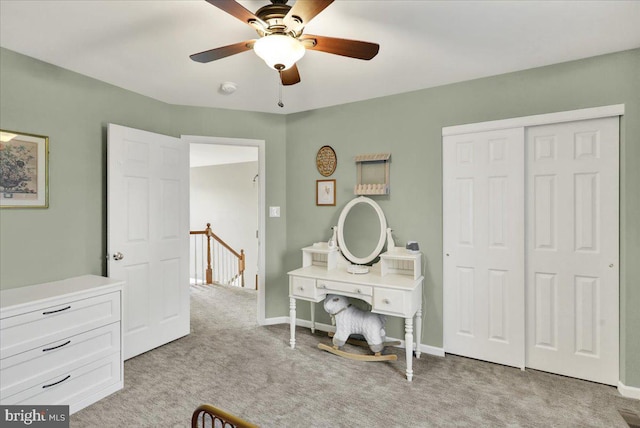 bedroom featuring a ceiling fan, baseboards, a closet, and light colored carpet