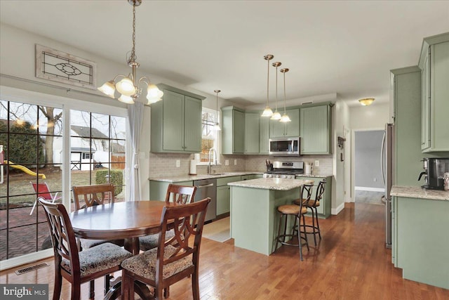 kitchen featuring stainless steel appliances, green cabinetry, and a kitchen island