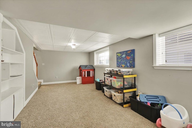 recreation room with carpet and baseboards