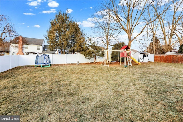 view of yard with a trampoline, a playground, a storage shed, a fenced backyard, and an outdoor structure