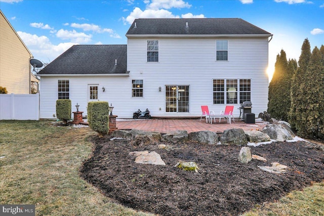 rear view of house with a shingled roof, a yard, fence, and a patio