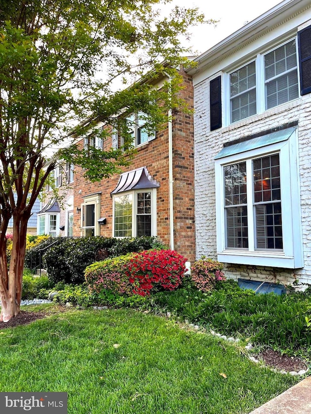 view of home's exterior with brick siding and a yard