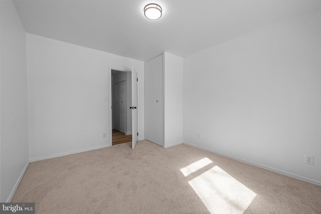 unfurnished bedroom with baseboards and light colored carpet