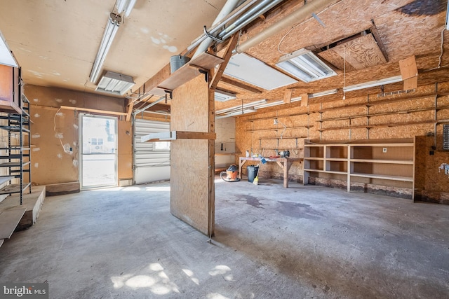 misc room with a garage and concrete flooring