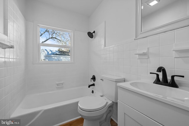 full bath featuring tile walls, toilet, vanity, washtub / shower combination, and backsplash