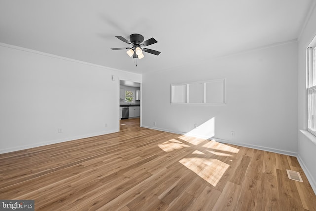 unfurnished living room featuring light wood finished floors, baseboards, visible vents, a ceiling fan, and ornamental molding