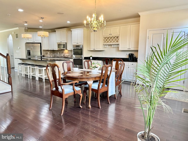 dining area featuring arched walkways, dark wood finished floors, crown molding, a notable chandelier, and recessed lighting